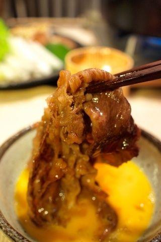photo: dipping a sukiyaki beef into fresh raw egg