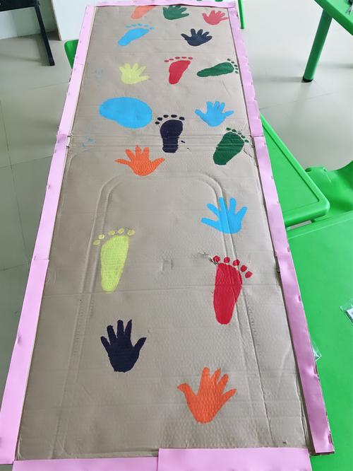 幼儿把自己的小手和小脚放在纸箱上相对应的手脚中,每个幼儿都可探索