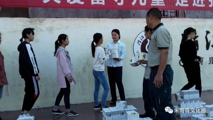 张金镇邮政支行工作人员在为张金中学留守儿童分发爱心图书