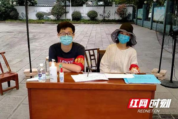 李博阳(左二)与小区物质保障供应组人员进行物资发放.