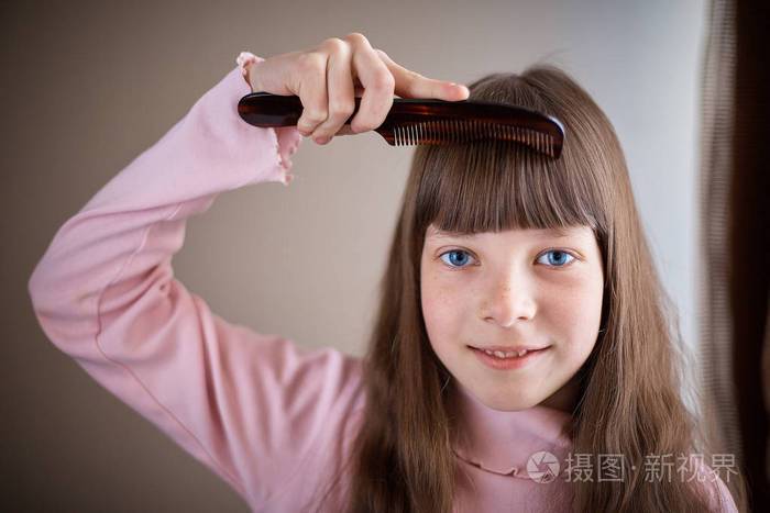 有雀斑和蓝眼睛梳头的小女孩梳头