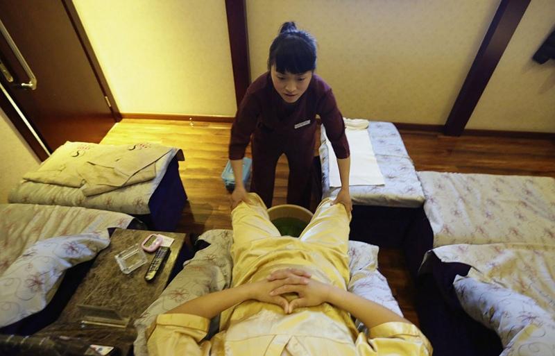 2月24日,北京望京的按摩店,王凤正为一名客人做足部按摩.