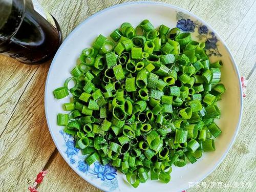 4. 在小葱碎上撒一层食用盐,再倒几滴香油,先让葱碎入味.