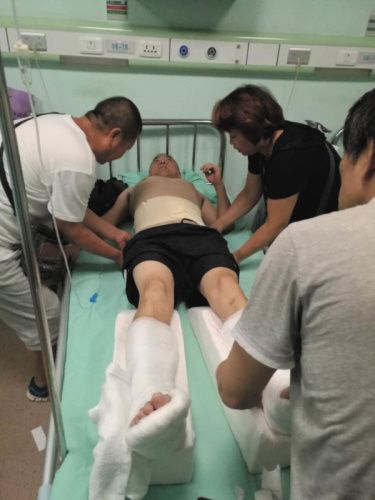 他正侧身躺在医院的病床上,双腿都打了石膏,腰部也缠上了绷带,床单上