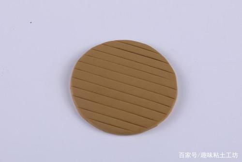 1,先来做放粽子的小笼屉,用棕色粘土做一个圆片.