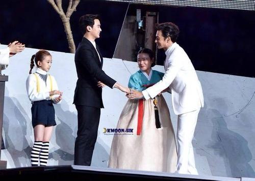 握手时:一边手伸出,另一只手轻轻托住伸出手的肘关节或压着衣服.