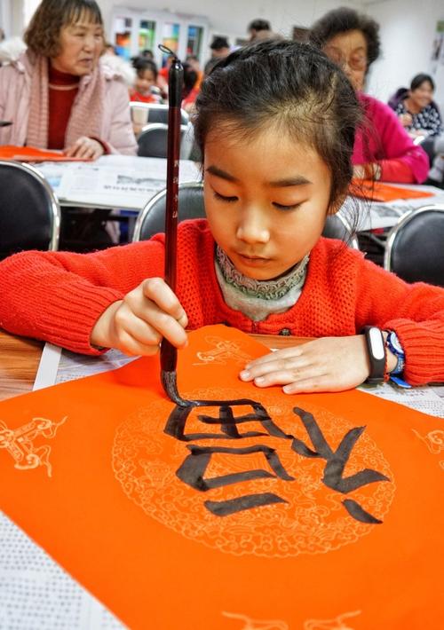 1月12日,中关村街道东裏北社区的一名儿童在活动现场写福字.