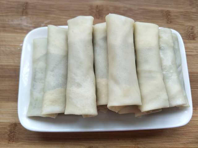 8,锅内倒入稍多的油,热至8成,放入春卷.