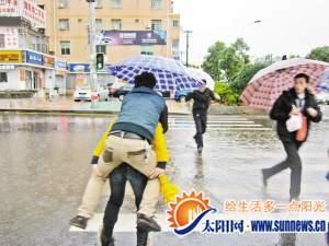 女汉子担心男友鞋子被浸湿 背起男友趟过积水