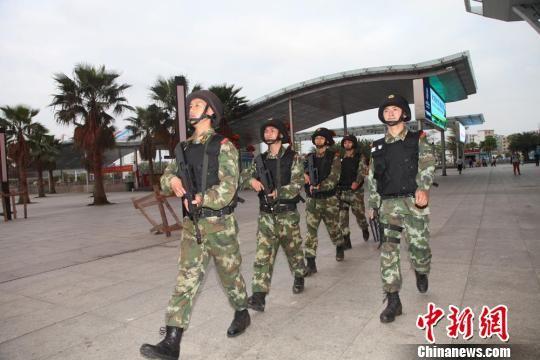 图为武警特战队员持枪在火车东站巡逻. 杨瑞明 摄