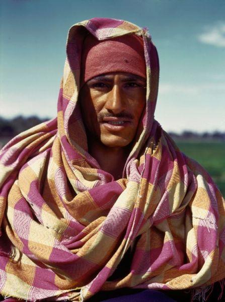 埃及,一个男人在身上裹着一块彩色的面料,这是为了避免被炙热的阳光