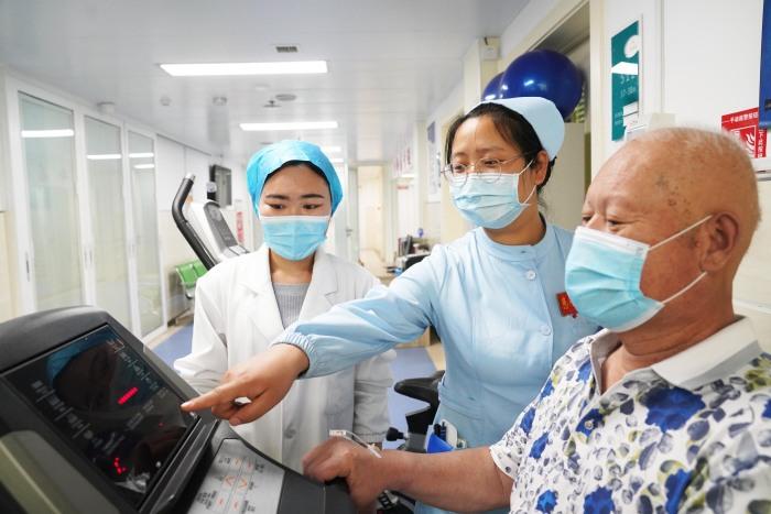 正在大学学习康复治疗专业的孙兴云(左)跟着重症科护士体验病人护理