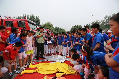 消防员展示向小学生们展示消防服