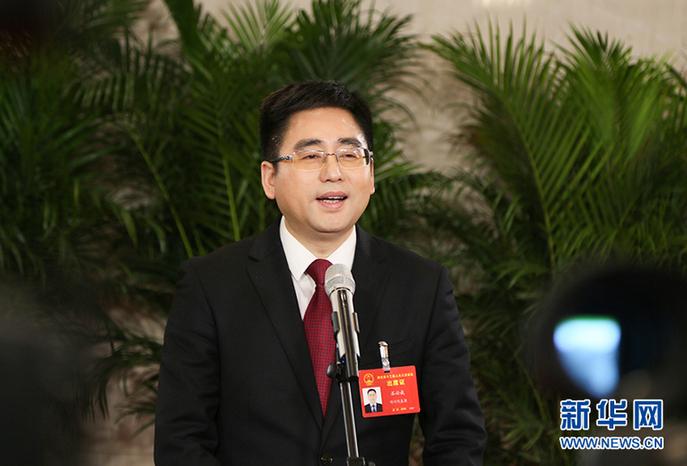 图为湖北省人大代表,石首市委书记,市长石必成在"代表通道"接受媒体