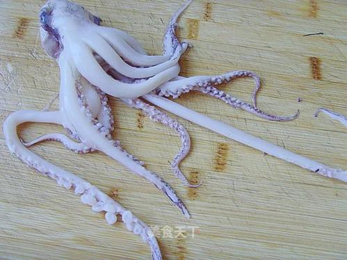 将将鱿鱼须的红褐色表皮撕掉,搓揉掉吸盘上的附着物,洗净.