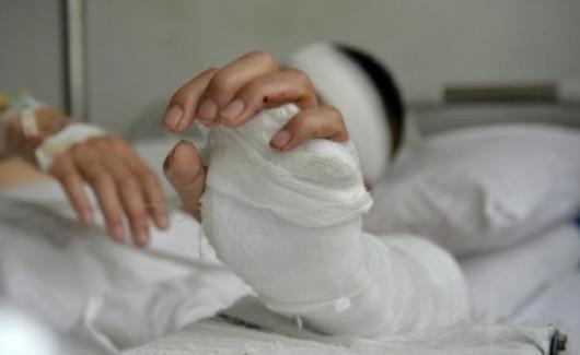 陈琦头缠绷带躺在病床上,向镜头展示自己打着石膏的左臂