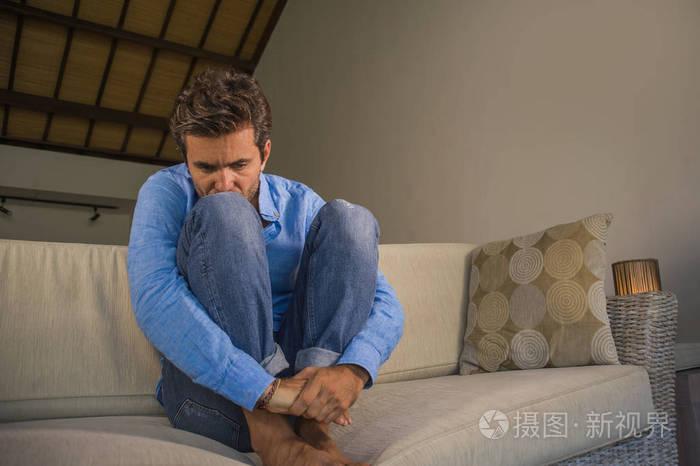 生活方式肖像年轻,有魅力,英俊,悲伤,拉丁男人,疲惫和沮丧地坐在家里