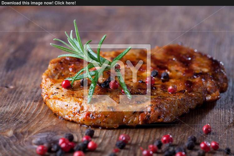 pork steak with pepper corns on wood