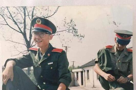 "照片中陆川身穿军装,坐在台阶上,戴着框架眼镜,笑容灿烂. 如此小鲜肉