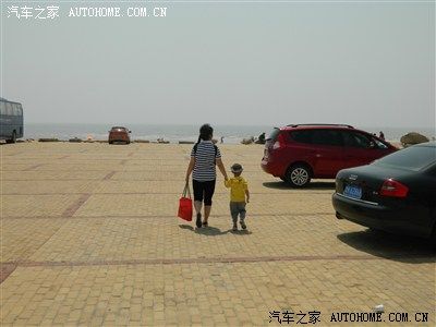 停车场内往海边走的娘俩背影