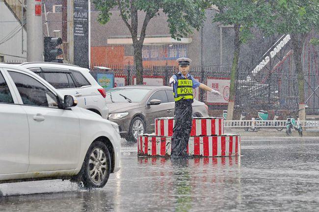 庆阳西峰交警雨中执勤 保障市民顺畅通行