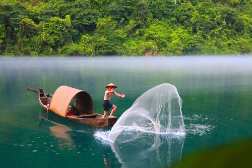 雾锁小东江,渔夫捕鱼忙.