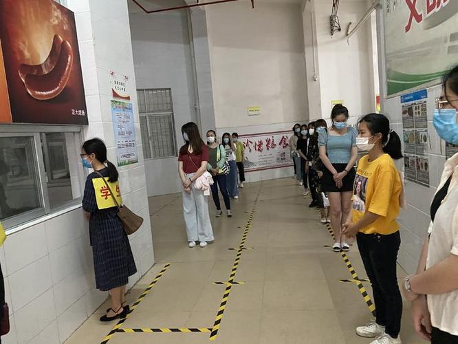体温正常学生洗完手根据排队打饭指示线排队打饭,饭堂工作人员给学生