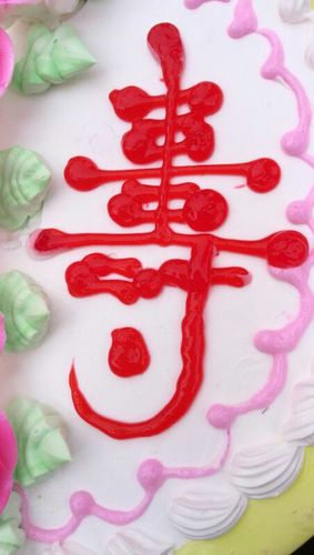 蛋糕上的大红寿字表达着我们对老人衷心的祝福.