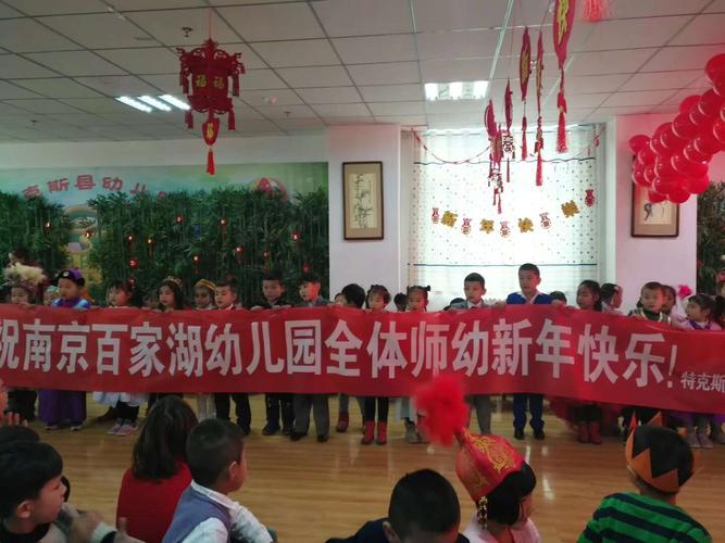 幼儿园各民族小朋友们共拉一条横幅,祝百家湖幼儿园全体师幼新年快乐