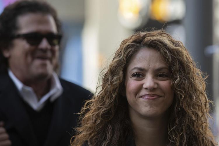 singers shakira, right, and carlos vives, background, arrive at