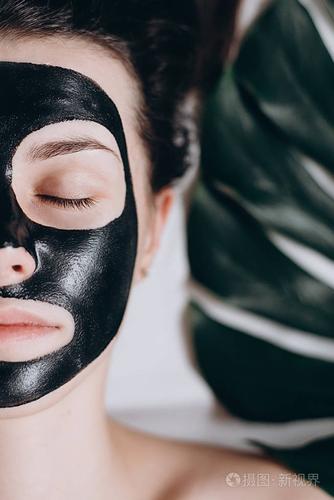 女人用黑色面膜放松. 健康和美丽的概念.