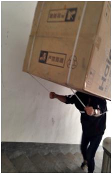 却没想到斜坡崎岖到只能步行,于是工作人员毅然决然的将冰箱背上,开始