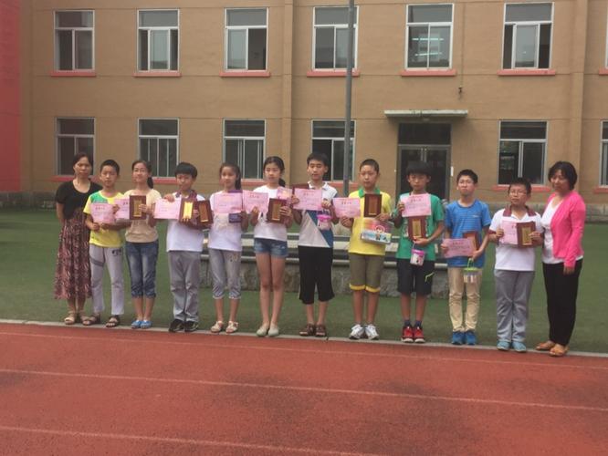 白塔小学校领导为参加区艺术节各项活动的同学颁发证书,奖品
