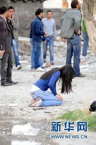 10月23日,在土耳其东部凡省,一名女子在地震后跪地痛哭.