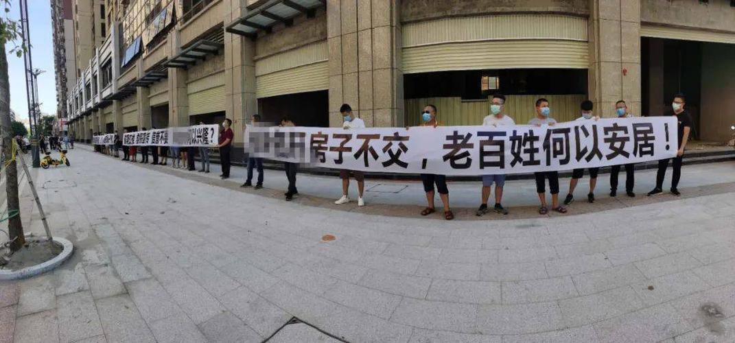 他们手拉横幅进行维权,要求开发商承诺交房时间,对延期交房讨要说法