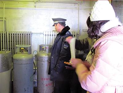 城管队员正在检查一家餐馆后厨的煤气罐.