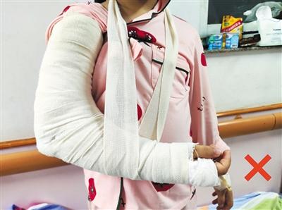 男孩手臂骨折打石膏爸爸用围巾兜脖子上