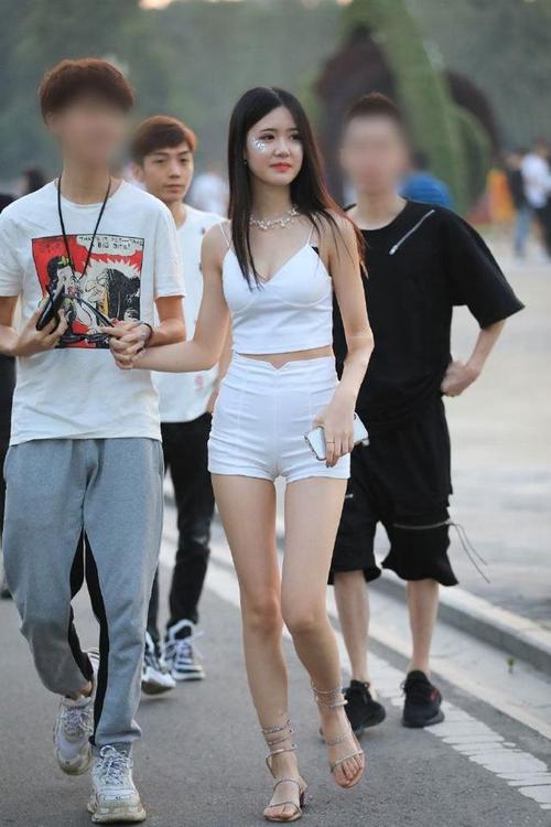 街拍白色的吊带肚脐装搭配紧身的热裤小姐姐的好身材一目了然