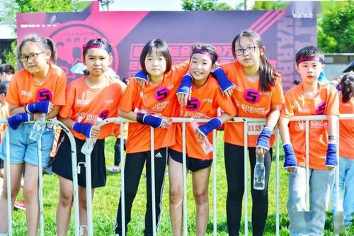 赛场里选手紧张奔跑挑战,赛场外还设有互动体验区,曲江体育青少年运动
