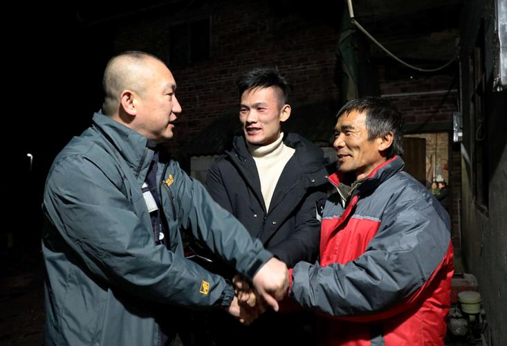 董标(中)与父亲董福清(右)与柳州融安供电局党委书记握手表示感谢之情