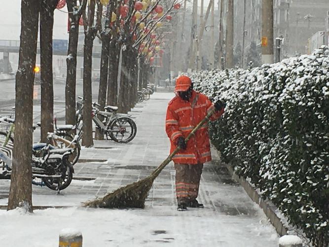 他们戴好口罩走上北京街头扫雪,这个举措防止环卫人员