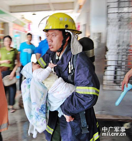消防官兵从大楼中抱出一个襁褓中的婴儿