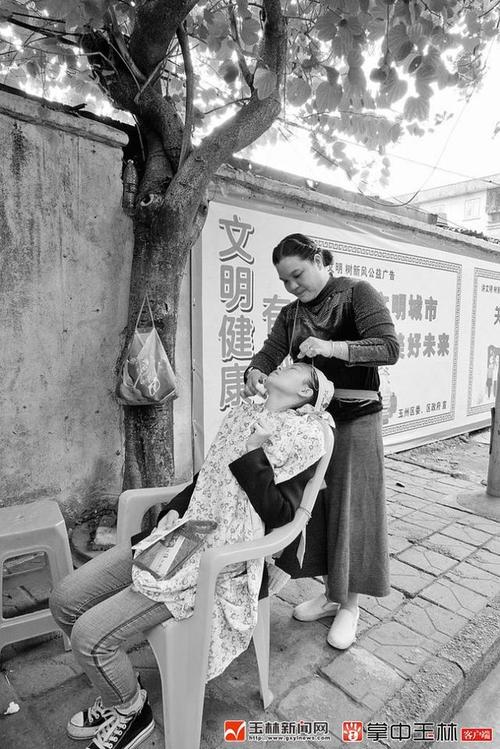 唐阿姨正在给顾客拔面毛.