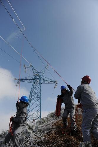 1月9日,毕节供电局梅花山除冰小队队员在威宁县新发乡境内对电力