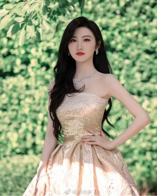 照片中,景甜披着秀发,化着红唇美妆,身穿抹胸款式礼服长裙大秀婀娜