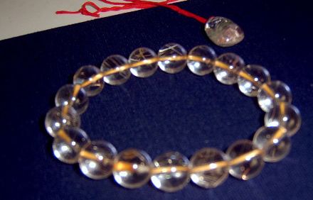 将水晶放在一根头发丝上,人眼透过水晶能看到头发丝双影的,则为天然