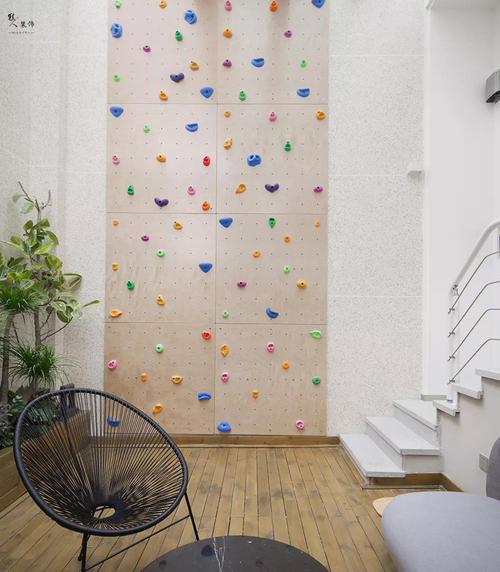 层高允许,在露台搭建了一面室内攀岩墙,跳跃的颜色和运动的活力让人