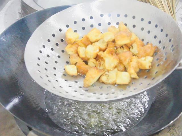 一根油条切成2厘米左右的丁;一根黄瓜拍扁后再斜切成小块,3-4颗大蒜拍