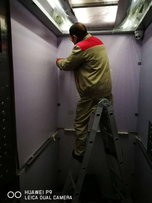 工程维修部师傅对电梯轿厢内防护板,给予加固.