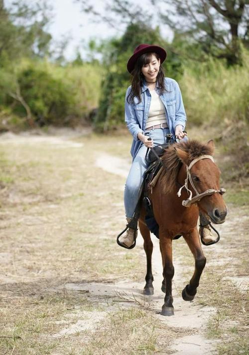 海边骑小矮马的美女,穿紧身牛仔裤,看起来清新靓丽很迷人